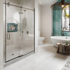 A modern bathroom featuring the CRL Crescent Series sliding glass shower door system in brushed stainless steel.