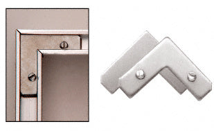 A close-up view showing aluminum corner sets with screws installed in a frame molding and a separate pair of corner brackets.