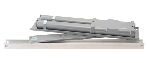 An aluminum finish LCN overhead concealed door closer with a slide track and double-acting mechanism.