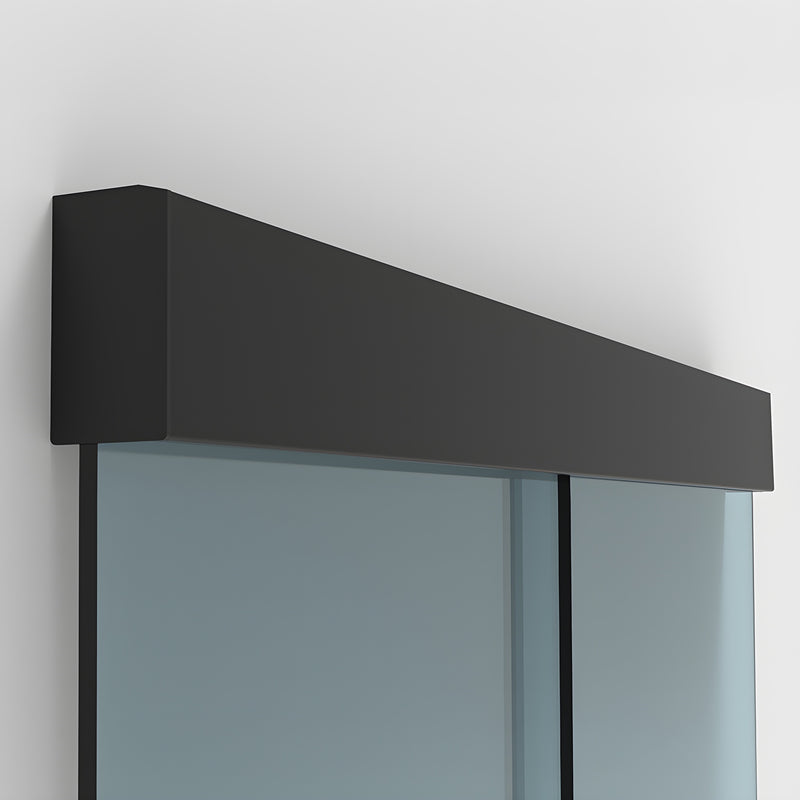 A close-up view of the matte black track cover installed above a glass sliding door system.