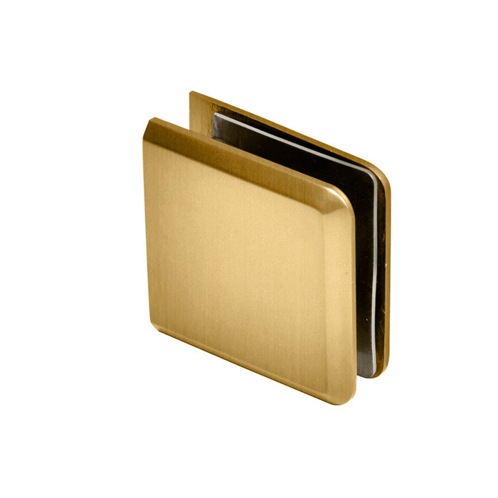 A close-up view of the satin brass beveled glass clamp showing its smooth finish.