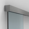 A brushed stainless steel track mounted to a wall with a glass sliding door panel.