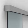 A satin anodized sliding door track mounted to a wall above a glass panel.