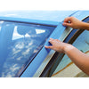 Hands applying blue 3M securing tape along the edge of a vehicle windshield and trim.