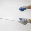 Hands wearing Atlas Fit rubber-coated work gloves securely gripping a clear sheet of glass.