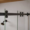 Close-up view of the stainless steel top roller hardware on the matte black Brixen sliding shower door system.