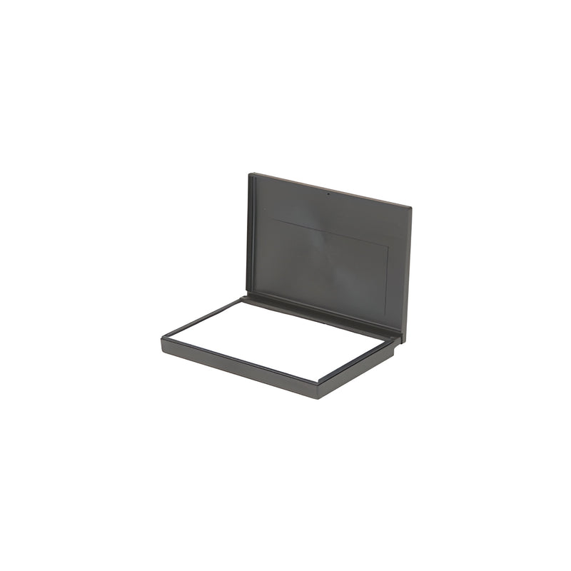 An open, empty black plastic stamp pad case with a white interior surface.
