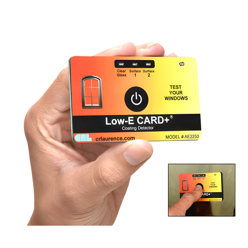 A hand holds the rectangular CRL AE2250 Low-E CARD+ coating detector, which features a power button and indicator lights for testing window glass.