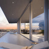 Palisades S100 sliding door (SKU P100S) slim aluminum frame with floor-to-ceiling glass opening to balcony and city sunset