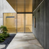 A modern commercial building entrance featuring a 250 Series glass door with dark bronze finish.