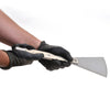 A person wearing protective gloves holds the CRL Persuader Urethane Chisel to demonstrate its size and grip.
