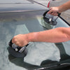 A person uses two 6-inch diameter suction cup glass handlers to lift a windshield on a vehicle.