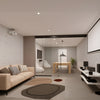 A modern living room featuring a matte black telescoping glass partition wall with right-stacking panels.