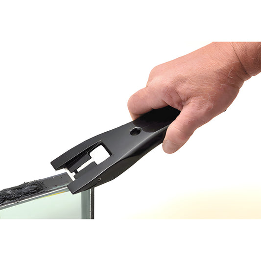 Black CRL insulating glass trim knife held in hand trimming hot melt butyl from the edge of an IG unit.