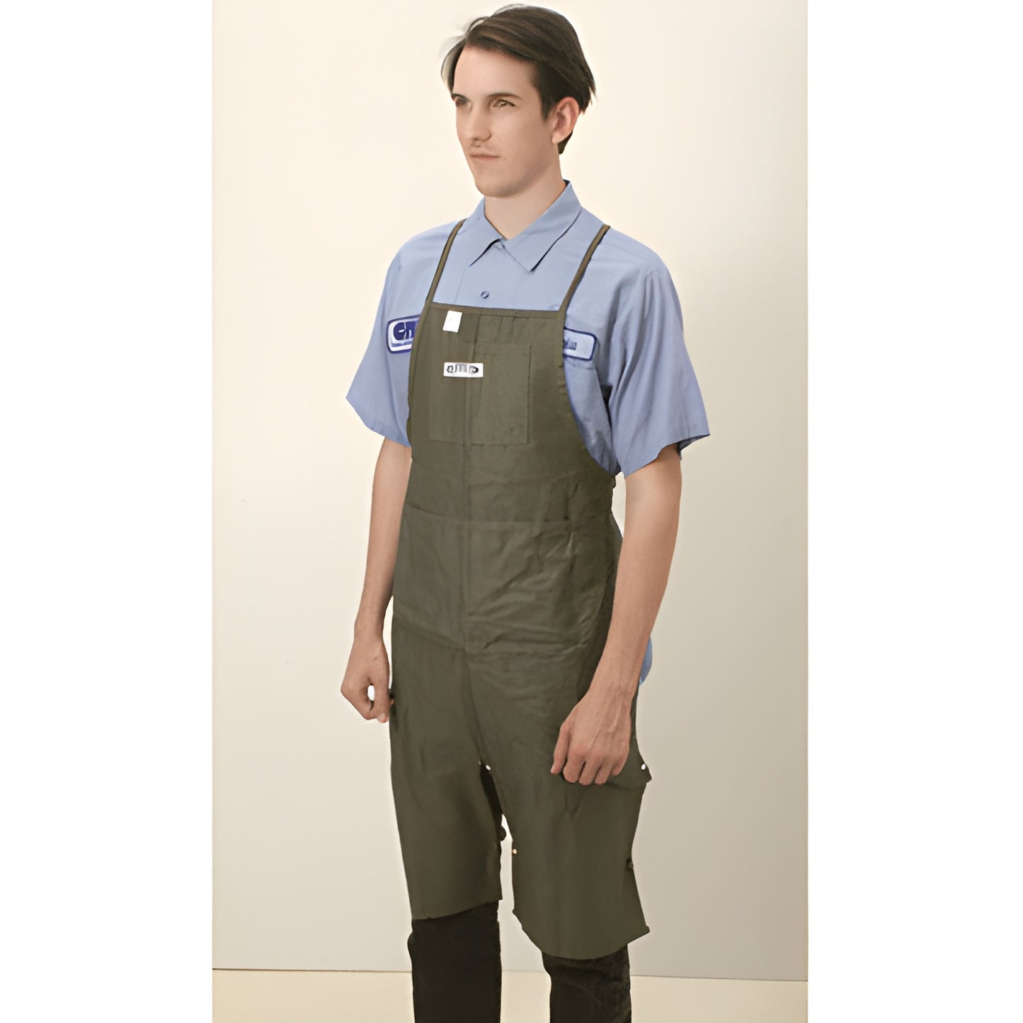 Green 10 oz cotton trucker apron (MNM71) with four pockets, harness and leg straps, worn over work shirt.